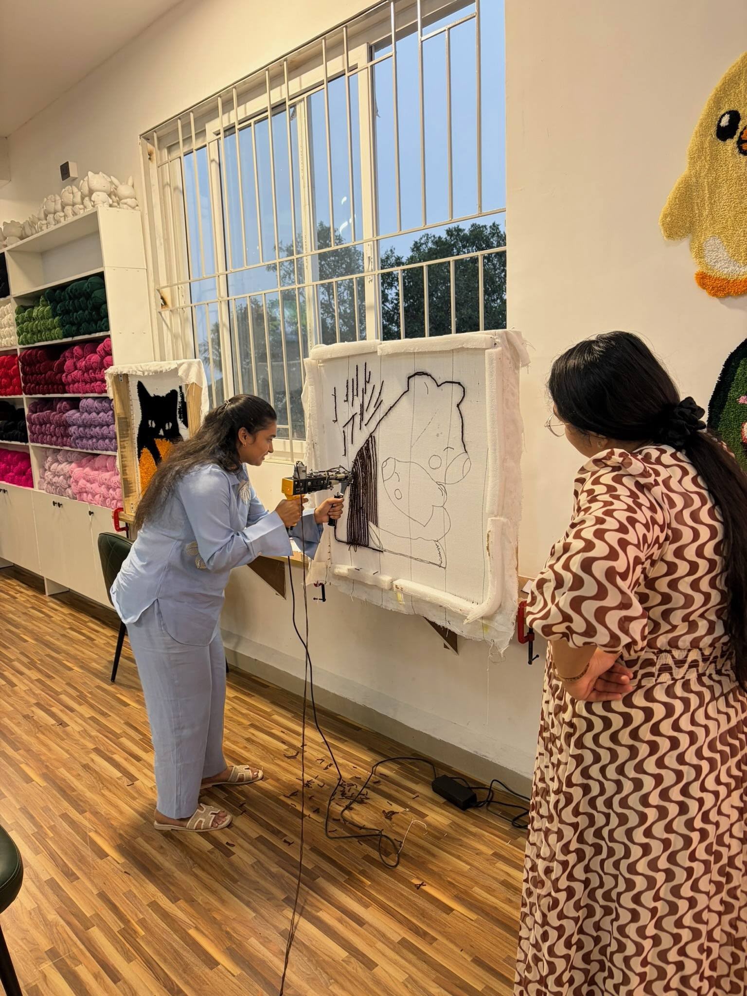 Guest tufting a design onto a stretched frame at Splashit